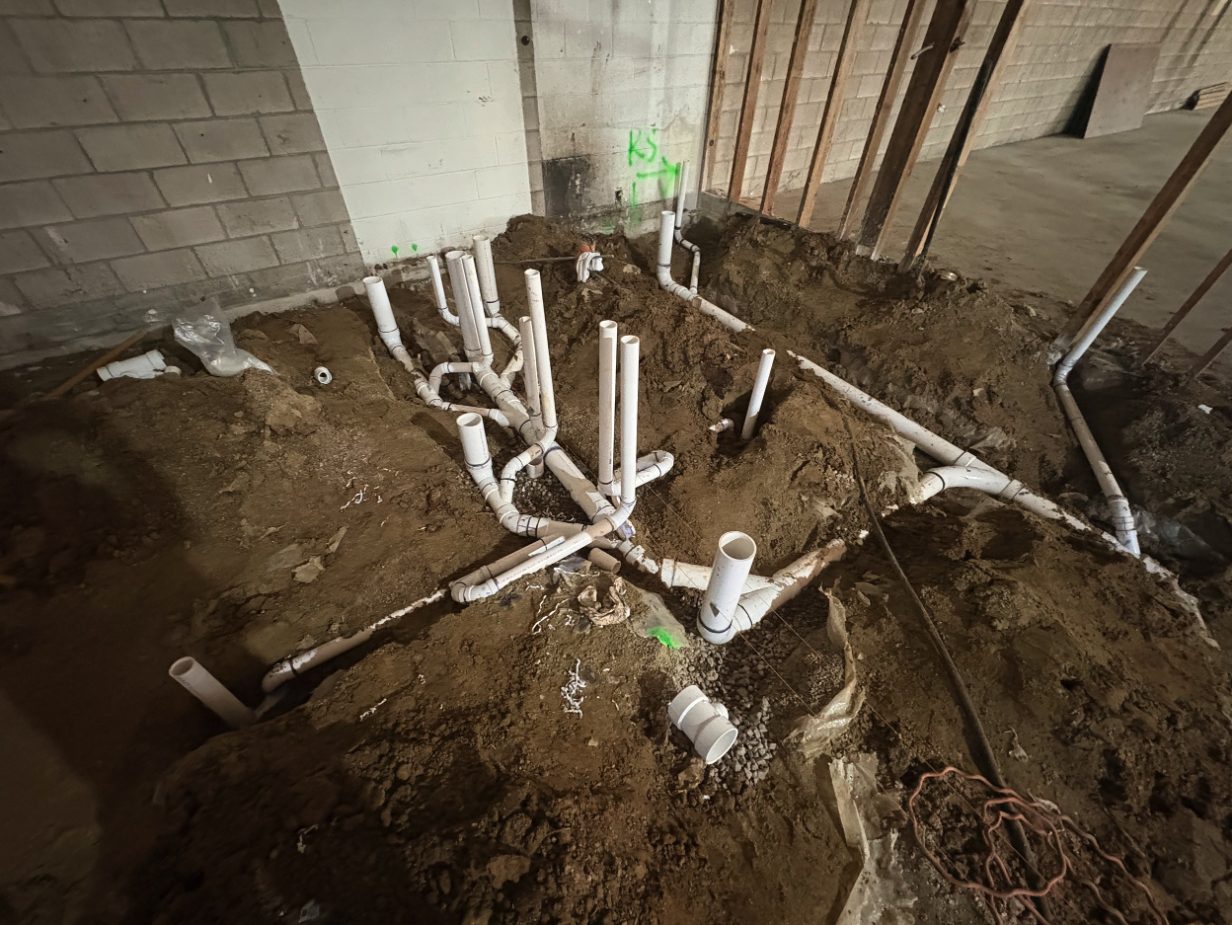 Underground waste and vent piping in a slab trench during a mall renovation