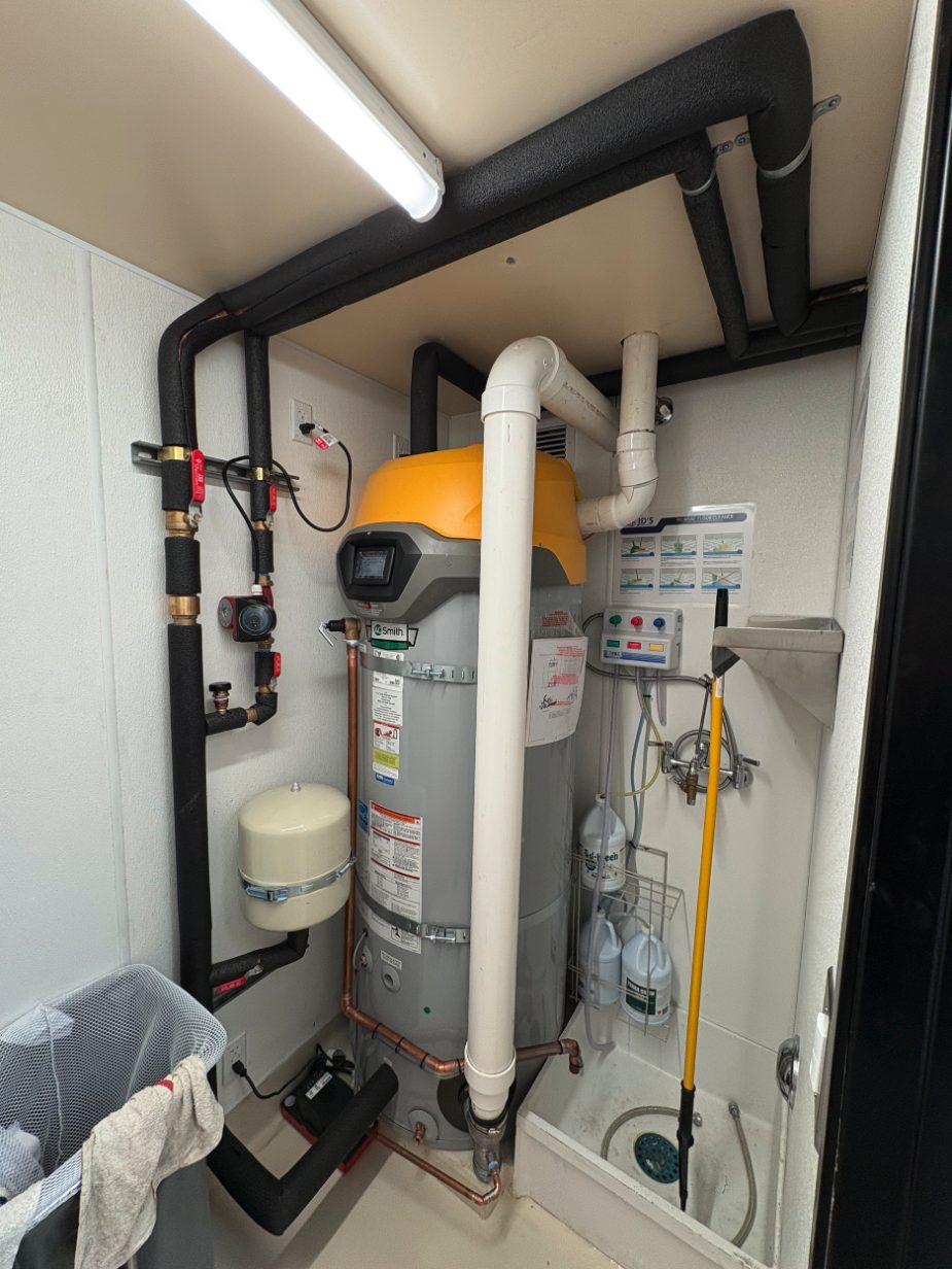 Commercial gas water heater for a restaurant with PVC venting, recirculation pump, expansion tank, and insulated piping